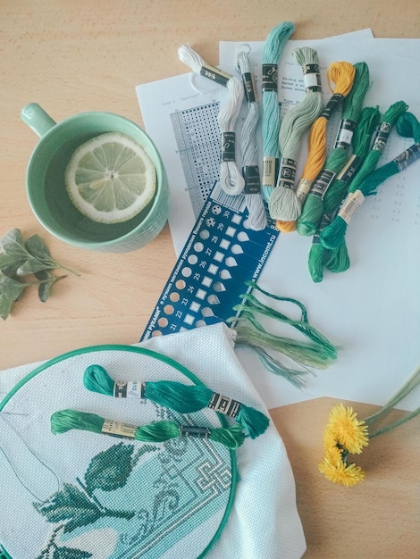 Mesa con herramientas de bordado y un cuaderno
